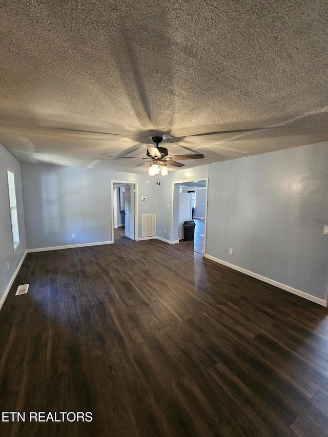 unfurnished room with a textured ceiling, dark hardwood / wood-style flooring, and ceiling fan