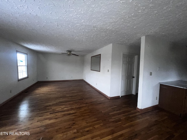 unfurnished room with ceiling fan, dark hardwood / wood-style flooring, and a textured ceiling