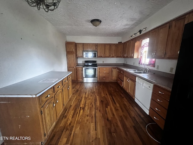 kitchen with dark hardwood / wood-style flooring, sink, stainless steel appliances, and a textured ceiling