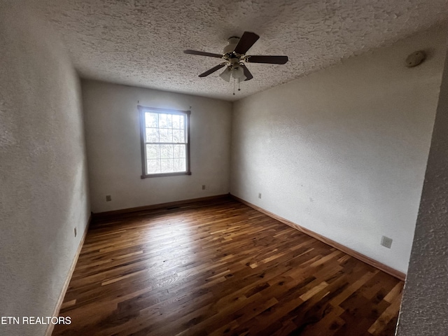 spare room with a textured ceiling, dark hardwood / wood-style flooring, and ceiling fan