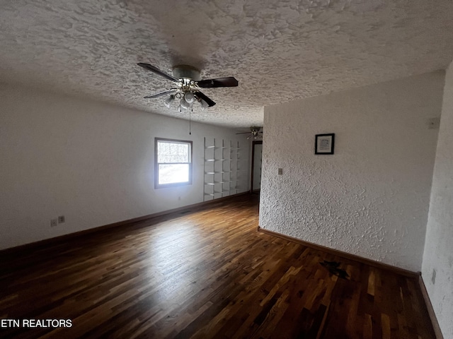 empty room with a textured ceiling, dark hardwood / wood-style floors, and ceiling fan