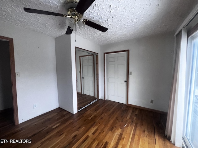 unfurnished bedroom with a textured ceiling, ceiling fan, and dark hardwood / wood-style floors