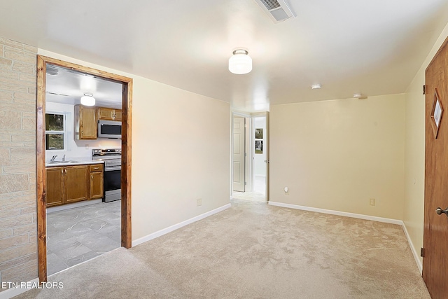 empty room featuring light colored carpet and sink