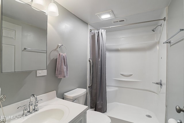 bathroom featuring curtained shower, vanity, and toilet