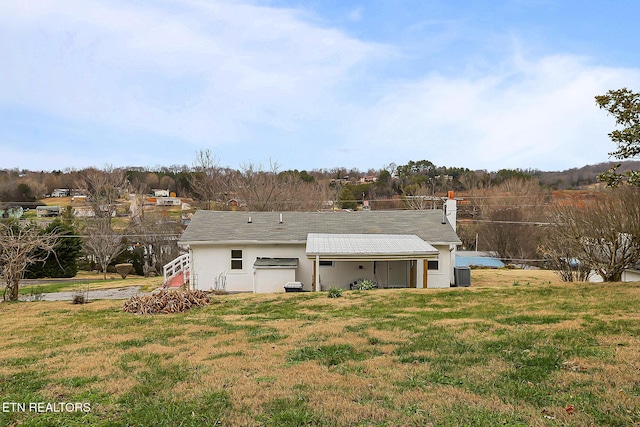 rear view of house with a yard and a garage