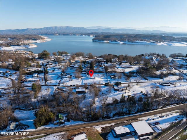 snowy aerial view with a water and mountain view