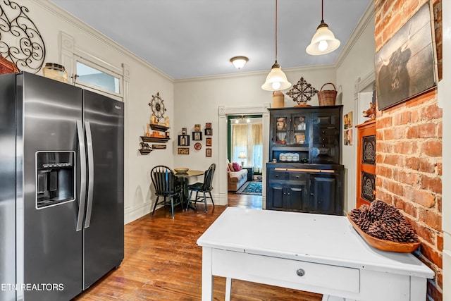 kitchen featuring hanging light fixtures, hardwood / wood-style flooring, stainless steel fridge, and ornamental molding