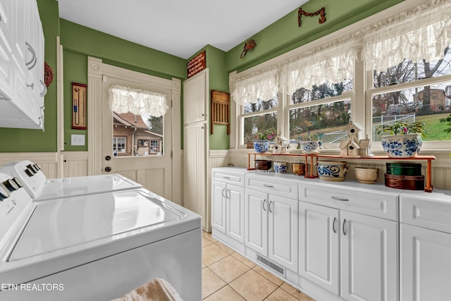 laundry room featuring cabinets, washing machine and dryer, and light tile patterned floors