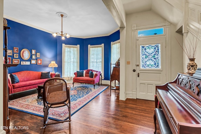 living room with dark hardwood / wood-style flooring, a notable chandelier, and ornamental molding