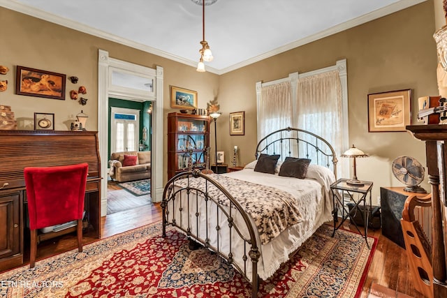 bedroom with crown molding and hardwood / wood-style floors