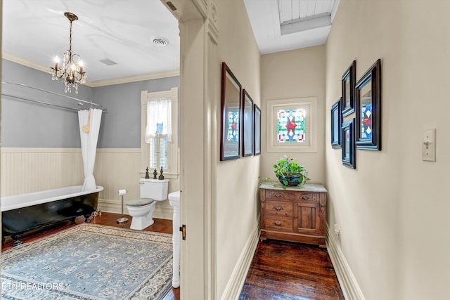 bathroom with hardwood / wood-style flooring, crown molding, an inviting chandelier, and toilet