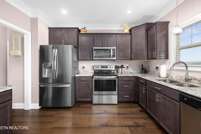 kitchen with pendant lighting, light stone countertops, sink, and stainless steel appliances