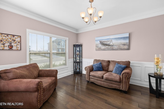 living room with dark hardwood / wood-style flooring, ornamental molding, and a chandelier