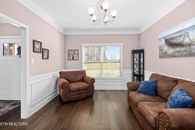 sitting room with dark hardwood / wood-style flooring, crown molding, and a chandelier