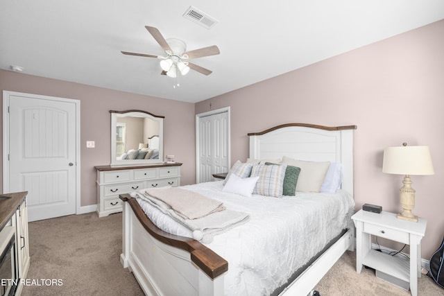 bedroom with ceiling fan, light colored carpet, and a closet