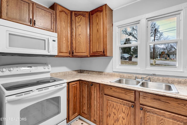 kitchen featuring white appliances and sink