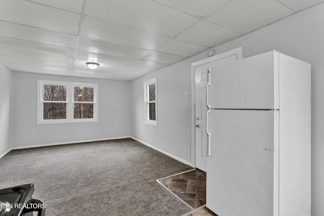 interior space featuring a paneled ceiling and carpet floors