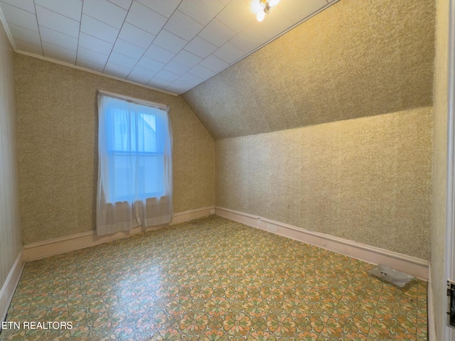 bonus room featuring vaulted ceiling, baseboards, and wallpapered walls