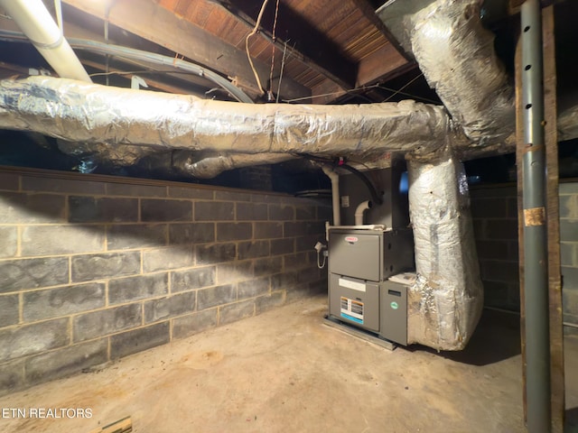 unfinished basement featuring concrete block wall