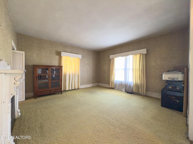 unfurnished living room with carpet flooring and baseboards