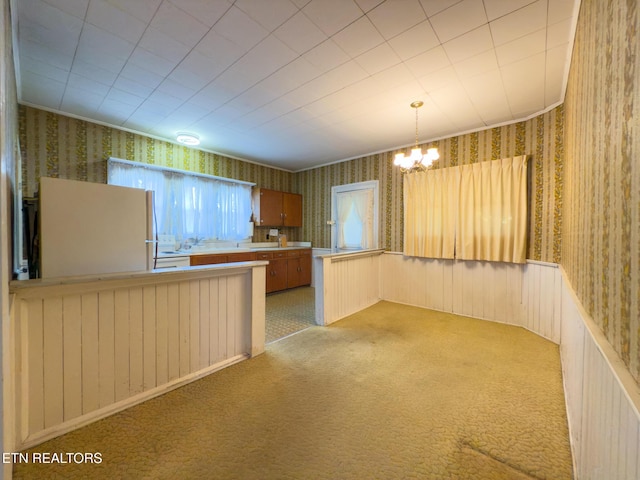 kitchen featuring light carpet, a peninsula, and wallpapered walls