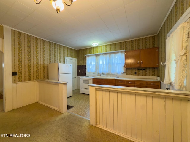 kitchen featuring light countertops, brown cabinetry, white appliances, a peninsula, and wallpapered walls