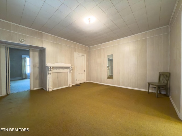 unfurnished living room featuring carpet, crown molding, and baseboards