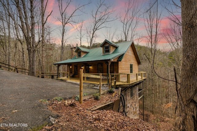 view of home's exterior featuring metal roof and a porch