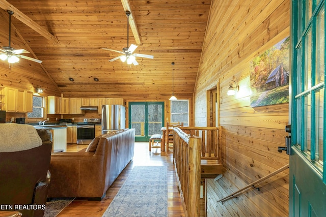 living room with beam ceiling, high vaulted ceiling, wood walls, wood-type flooring, and wood ceiling