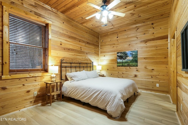 bedroom with ceiling fan, wood ceiling, wooden walls, and light hardwood / wood-style flooring