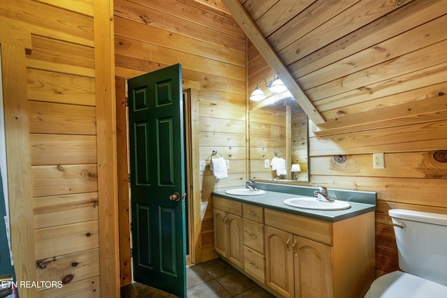 bathroom with wooden ceiling, tile patterned floors, vaulted ceiling, wooden walls, and vanity