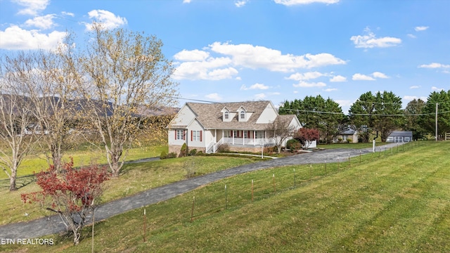 cape cod house featuring a porch and a front lawn