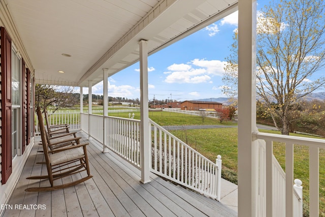 deck featuring a lawn and a porch