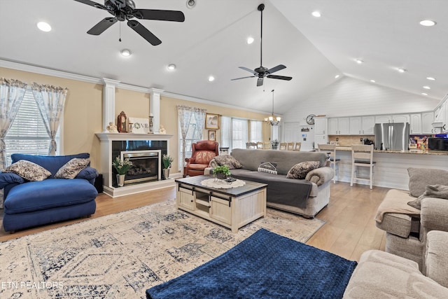 living room featuring plenty of natural light, light hardwood / wood-style flooring, and ceiling fan with notable chandelier