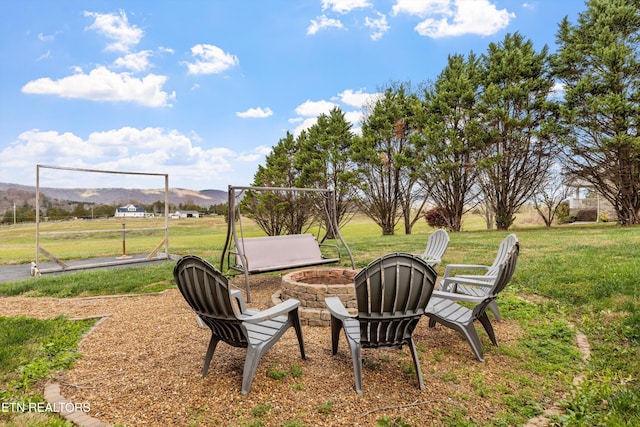 view of yard featuring a mountain view and an outdoor fire pit