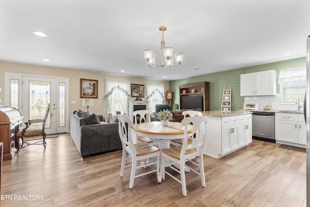 dining room with plenty of natural light, light hardwood / wood-style flooring, and an inviting chandelier