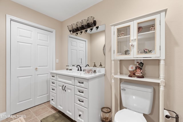 bathroom with tile patterned flooring, vanity, and toilet