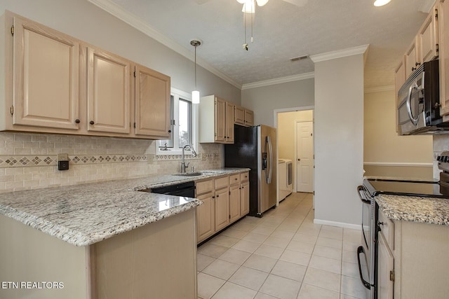 kitchen with light stone countertops, appliances with stainless steel finishes, sink, washer and clothes dryer, and kitchen peninsula