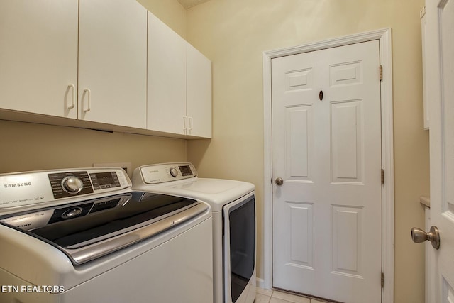 laundry room featuring light tile patterned floors, cabinets, and independent washer and dryer