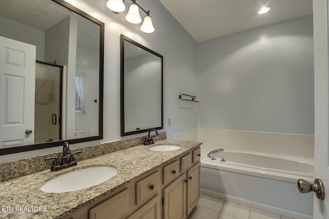 bathroom featuring independent shower and bath, vanity, and tile patterned flooring