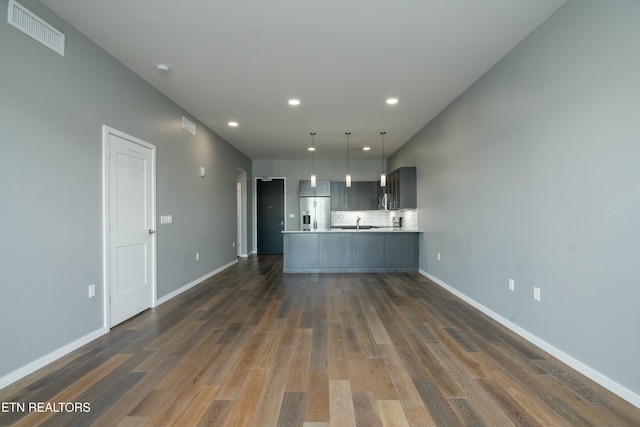 kitchen with dark hardwood / wood-style flooring, kitchen peninsula, stainless steel fridge with ice dispenser, and tasteful backsplash