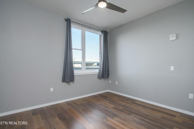 empty room with ceiling fan and dark wood-type flooring