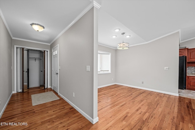 entrance foyer with ornamental molding and light wood-type flooring