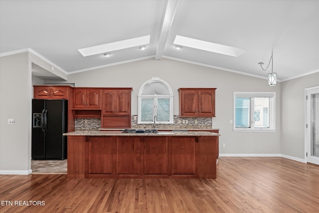 kitchen featuring black fridge with ice dispenser, a center island, light hardwood / wood-style floors, tasteful backsplash, and lofted ceiling with skylight