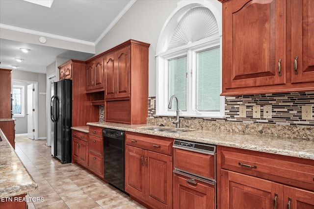 kitchen with light stone counters, a healthy amount of sunlight, black appliances, tasteful backsplash, and sink