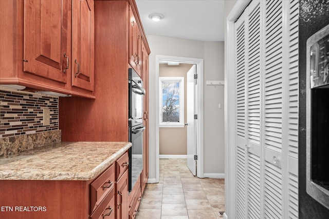 kitchen with double oven, light tile patterned floors, and decorative backsplash