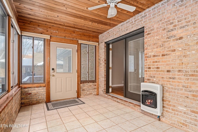 unfurnished sunroom featuring ceiling fan, heating unit, and wood ceiling