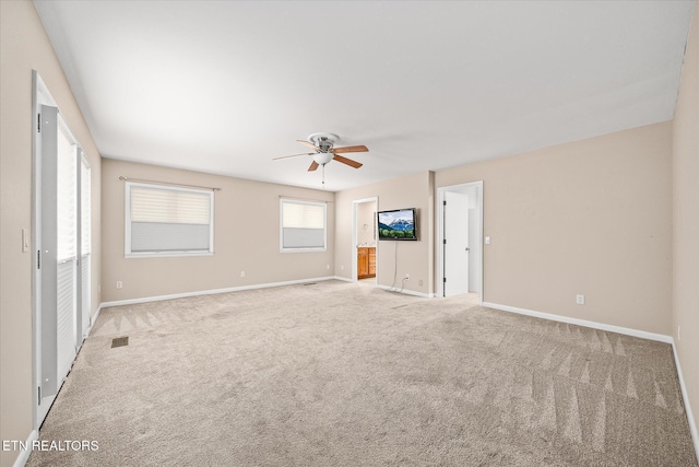 unfurnished living room featuring light carpet and ceiling fan