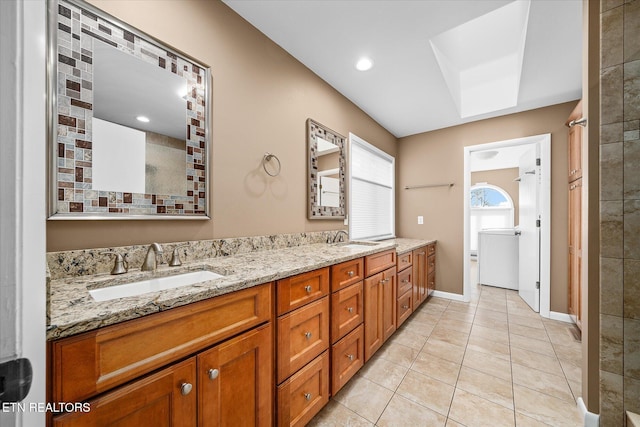 bathroom featuring washer / clothes dryer, vanity, tile patterned floors, and a skylight