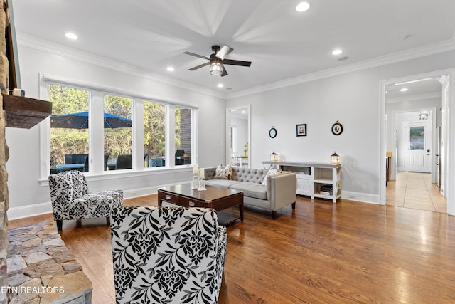 living room with hardwood / wood-style flooring, ceiling fan, and crown molding